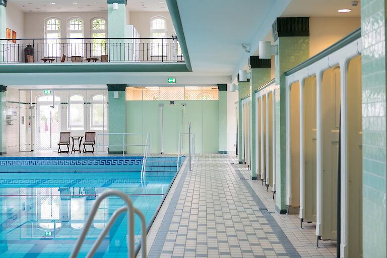 Schwimmhalle mit basilikale Gewölbe. Mehrzweckbecken sowie die Umkleiden, die auf zwei Etagen um das Becken herum verteilt sind.