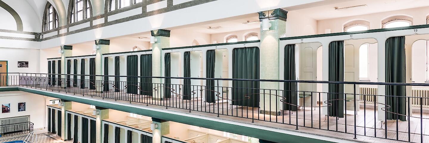 Schwimmhalle mit basilikale Gewölbe. Die Umkleiden sind auf zwei Etagen um das Becken herum verteilt.