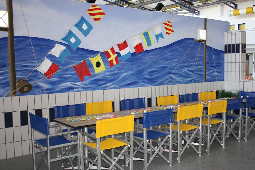 Eine Kindergeburtstagsecke im Freizeitbad Düsselstrand. Diese besteht aus einem langen Tisch mit Stühlen.