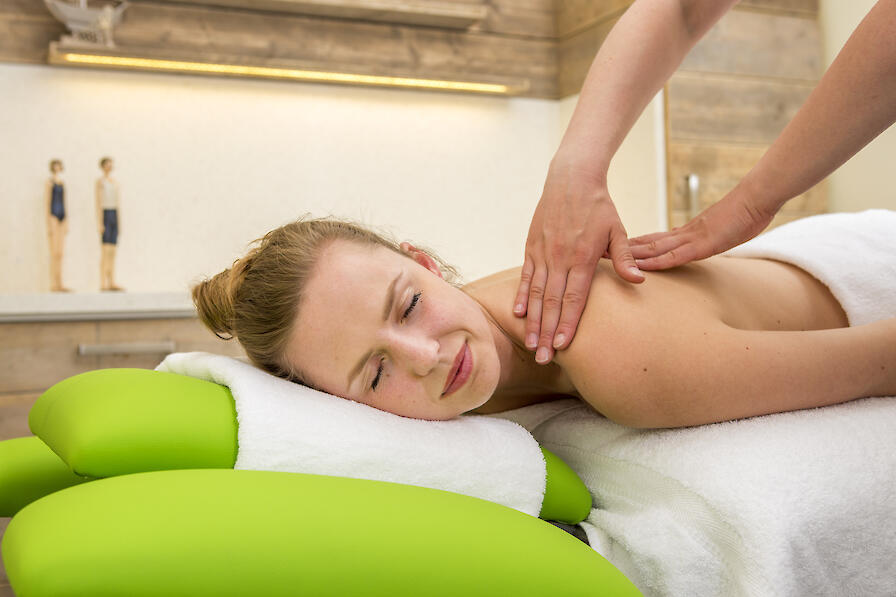 Eine Frau wird am Rücken massiert.