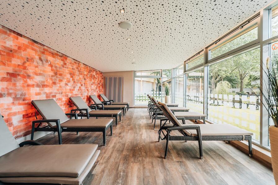 Salzraum mit vielen Liegen und einem Panoramablick in den Saunagarten.