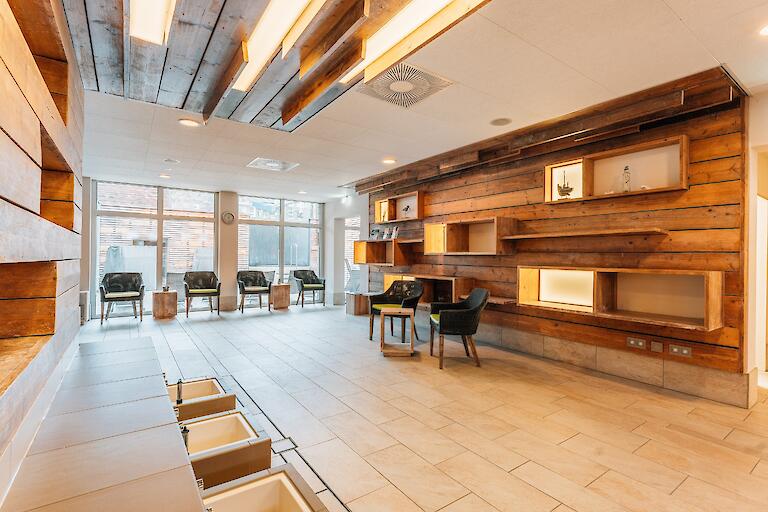 Saunavorraum mit mehreren Liegen, Fußbädern und Stühlen.