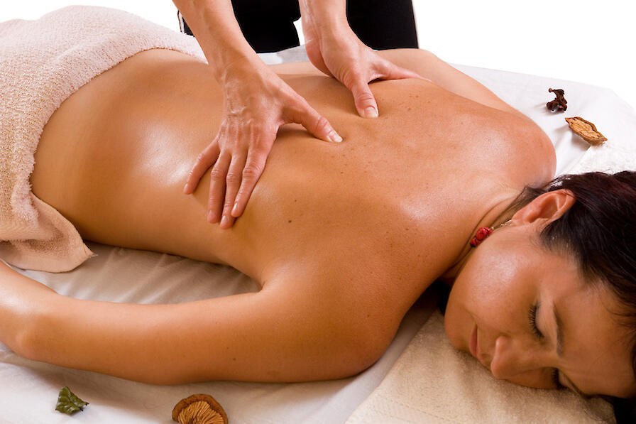 Eine Frau wird am Rücken massiert.