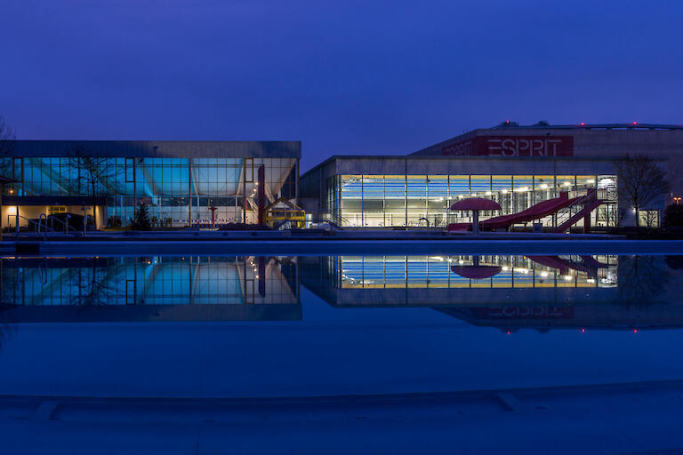 Außenansicht bei Nacht von der 33m-Halle, der 50m-Halle und dem Freibad.