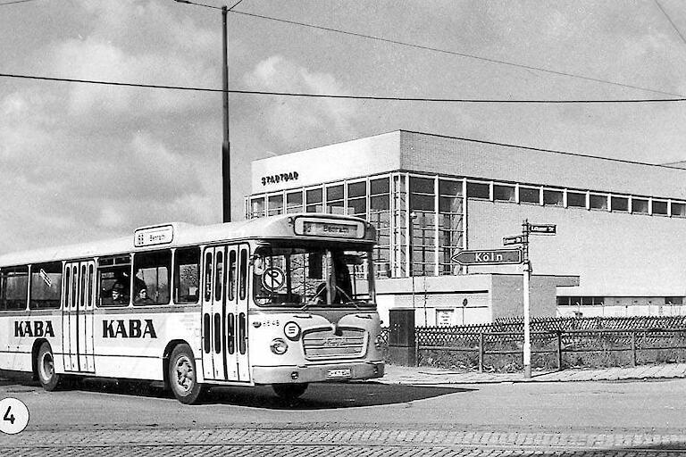 Alte Außenansicht des Bades in schwarz/weiß mit einem alten Bus davor.