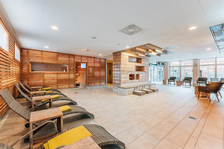 Saunavorraum mit mehreren Liegen, Fußbädern und Stühlen.