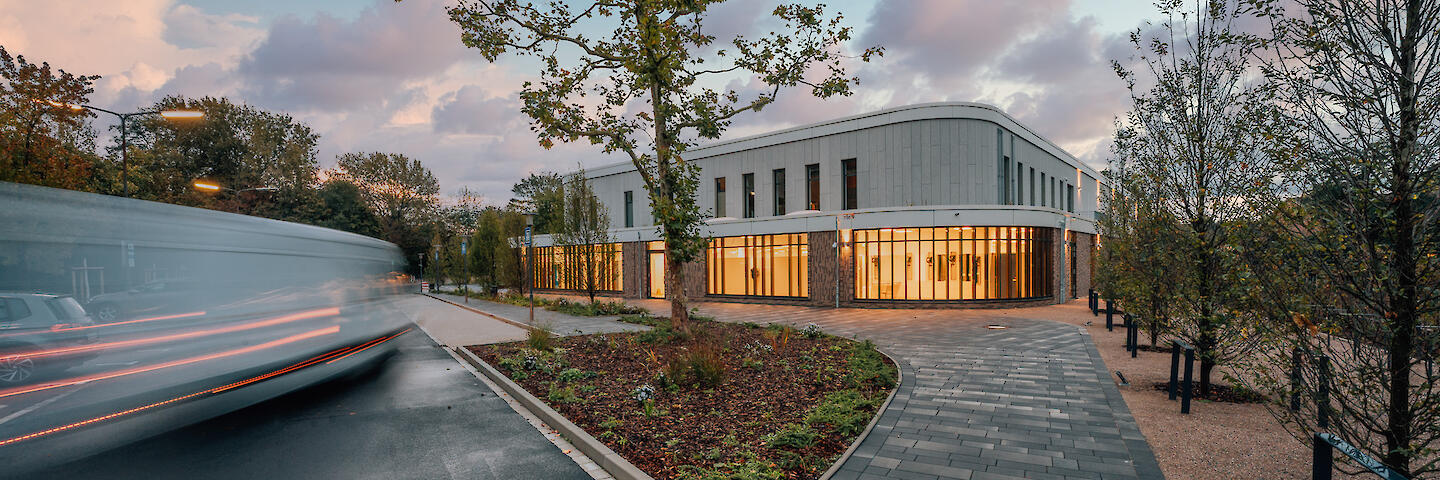 Außenansicht vom Badehaus Benrath mit ein paar Bäumen und einem Parkplatz.