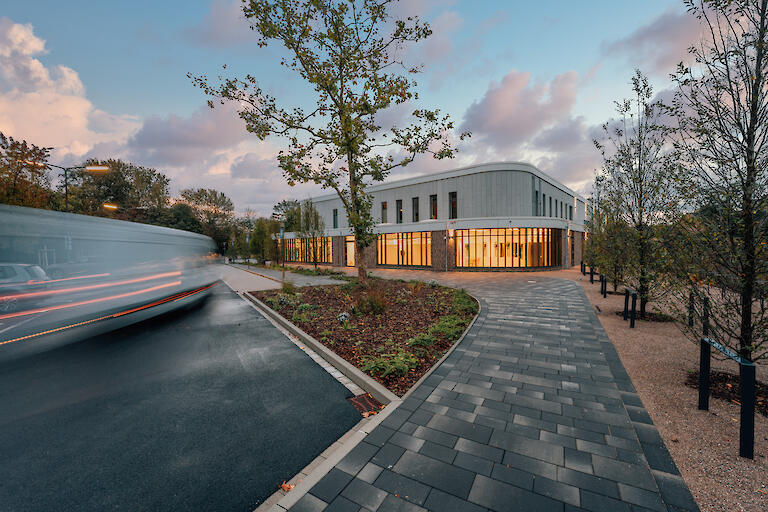 Außenansicht vom Badehaus Benrath mit ein paar Bäumen und einem Parkplatz.