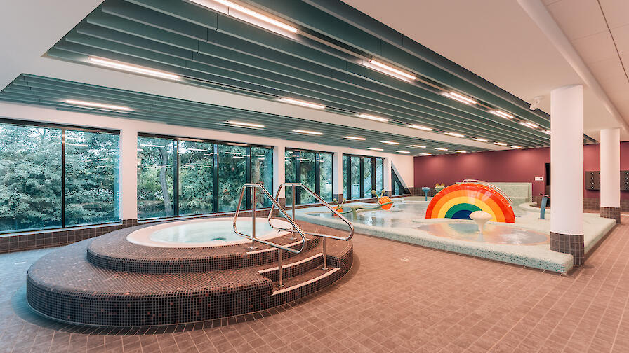 Kinderplanschbecken mit verschiedenen Attraktionen für Kinder sowie einem runden Warmwasserbecken.